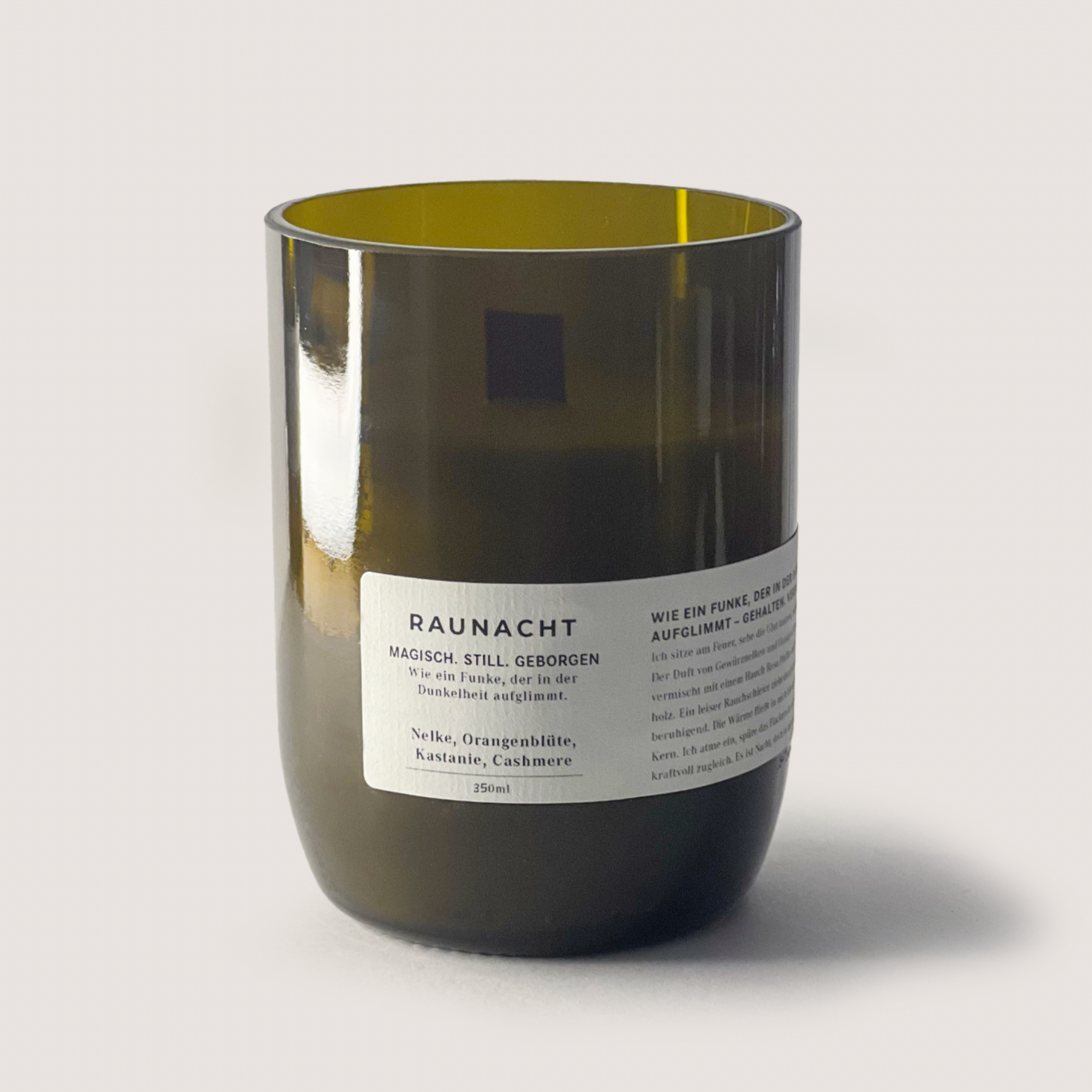 RAUNACHT 200ml candle with clove, orange blossom, chestnut, and cashmere scent in a dark glass container